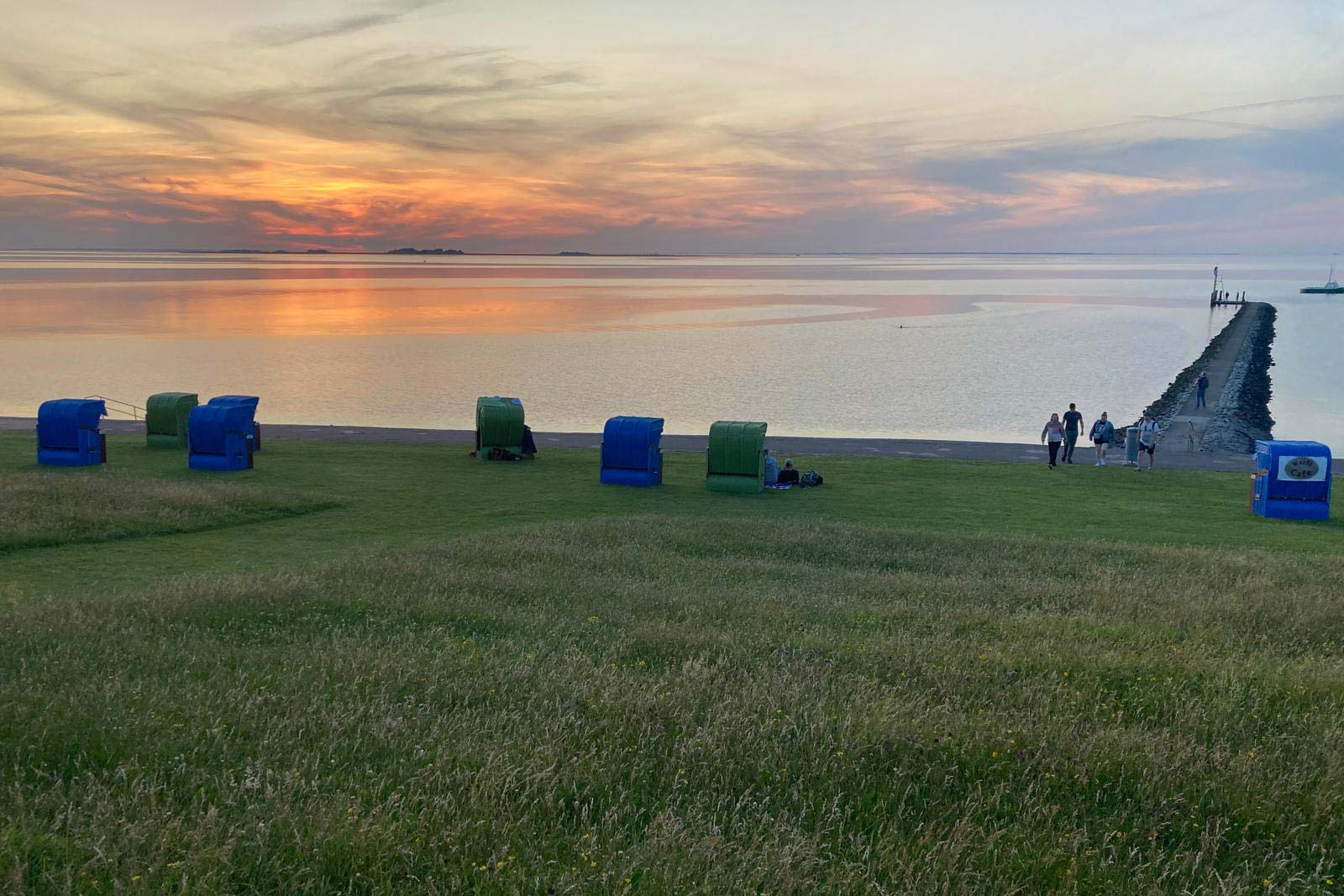 Urlaubstag am Strand - Deich mit Strandkörben und Abendstimmung am Himmel