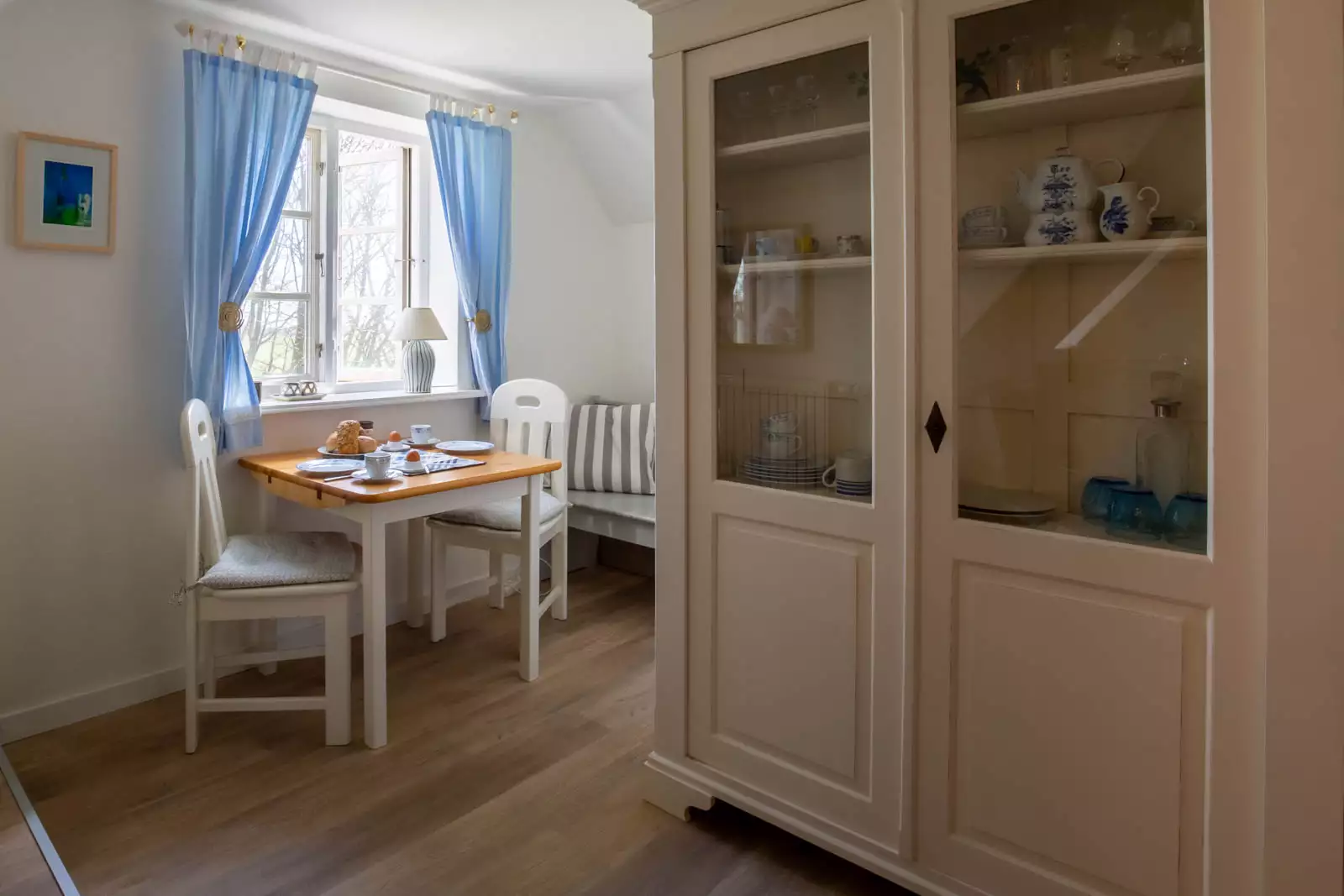 Essplatz der Ferienwohnung Vogelkoje auf Pellworm mit gedecktem Tisch für zwei Personen und Küchenschrank