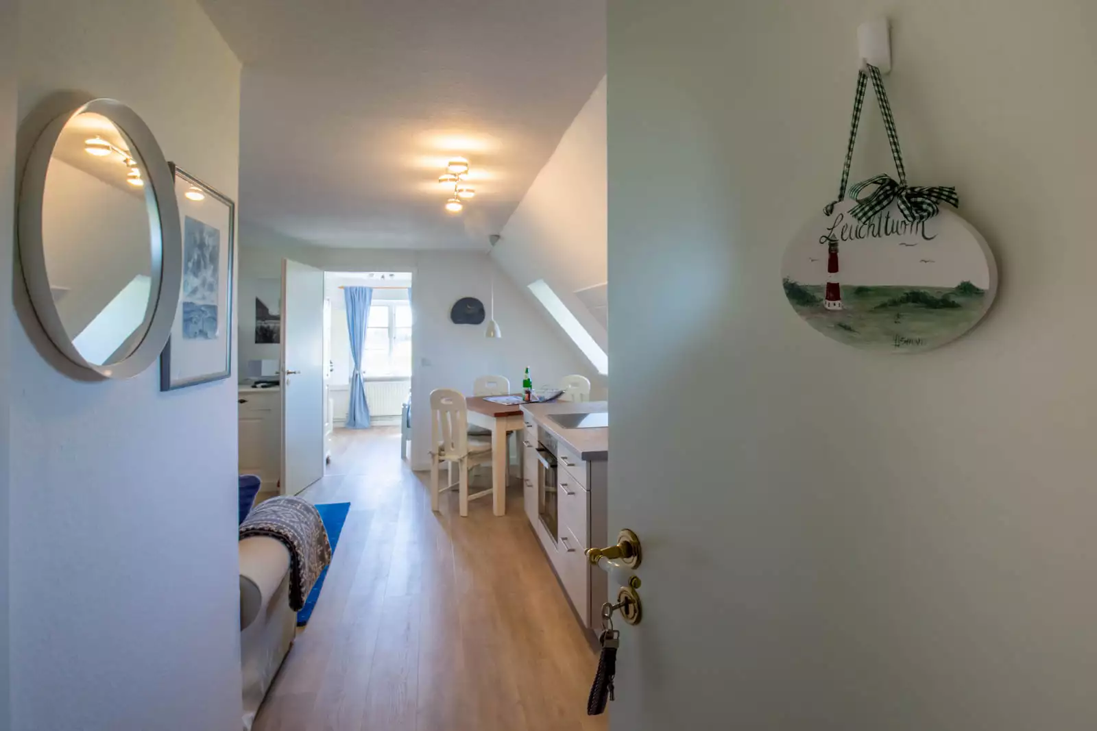 Blick von der Eingangstür durch den Wohnraum der Ferienwohnung Leuchtturm auf Pellworm bis ins Schlafzimmer