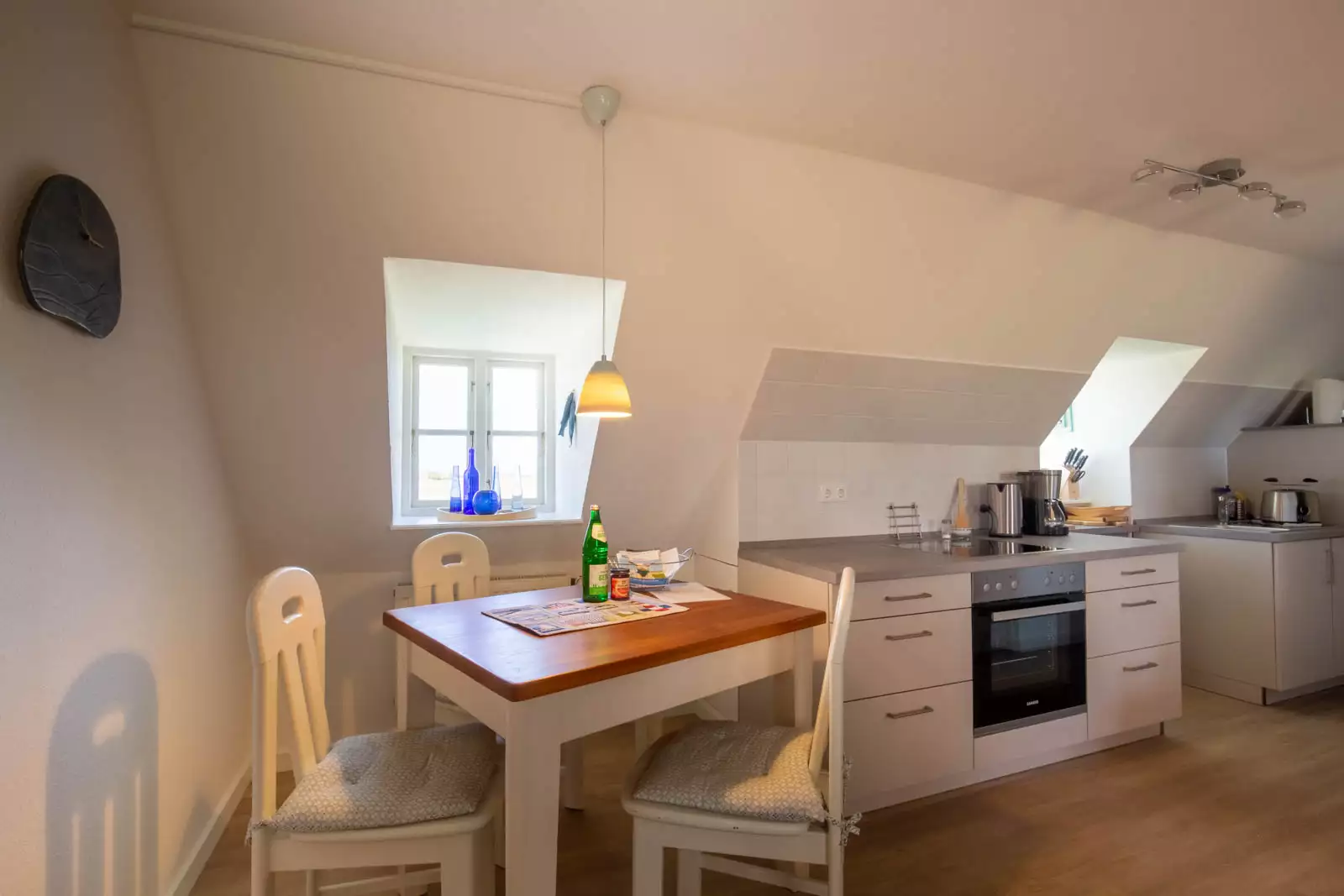 Essecke der Ferienwohnung Leuchtturm auf Pellworm mit Tisch, Stühlen und Ausschnitt der Küchenzeile