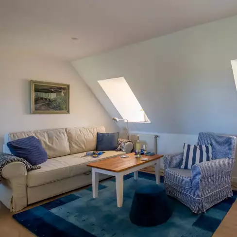 Wohnbereich der Ferienwohnung Vogelkoje auf Pellworm mit Couchecke und angeschnittener Küchenzeile