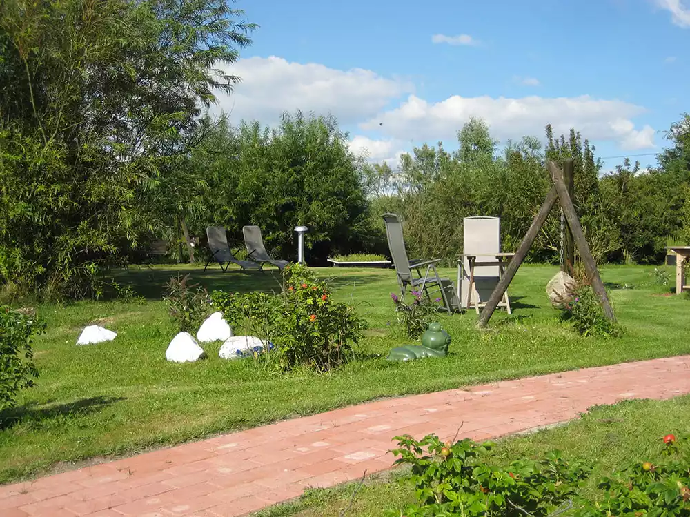 Garten des Ferienhauses Kiek in’t Land auf Pellworm mit Bäumen, Hecken, Gartenmöbeln und ruhiger Alleinlage